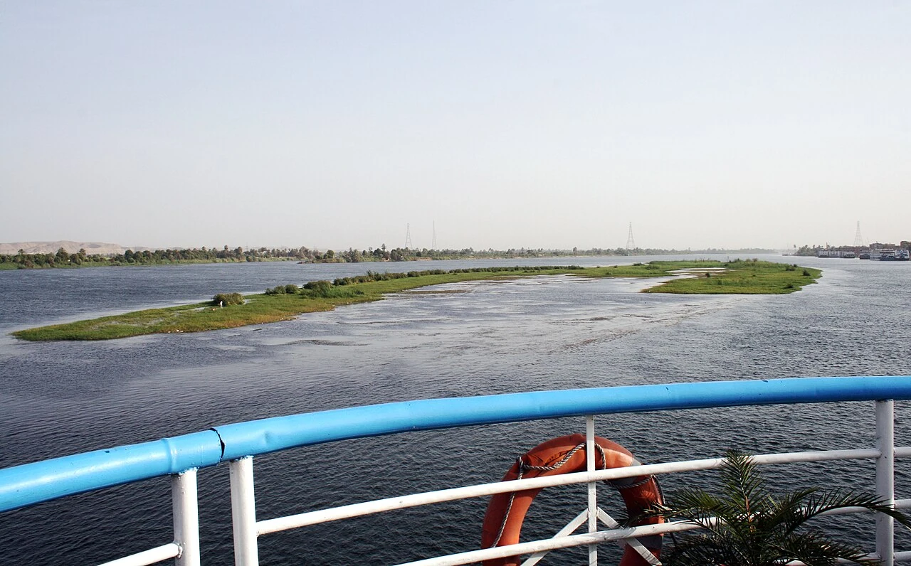The Nile near Edfu, with part of a deck and railing in the foreground